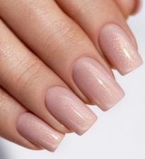 Delikatny brzoskwiniowy manicure z dodatkiem błyszczącego złota