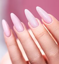 Elegancki manicure z połyskującymi drobinkami w rozbielonym różu